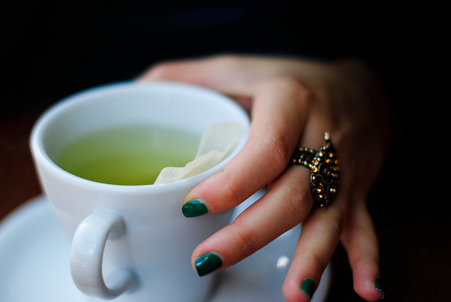 Woman holding cup of green tea