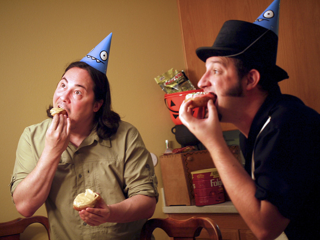 coworkers eating donuts in party hats
