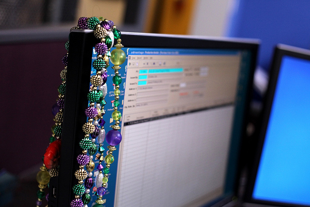 Mardi Gras beads on computer monitor