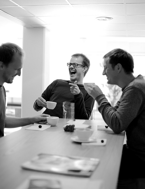 happy coworkers laughing over coffee