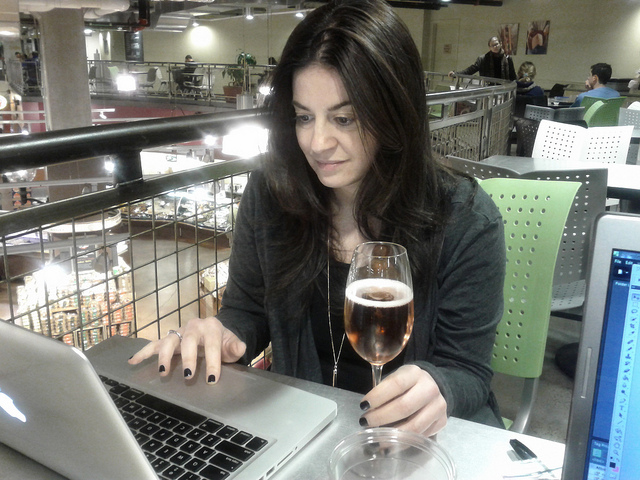 woman drinking wine at laptop