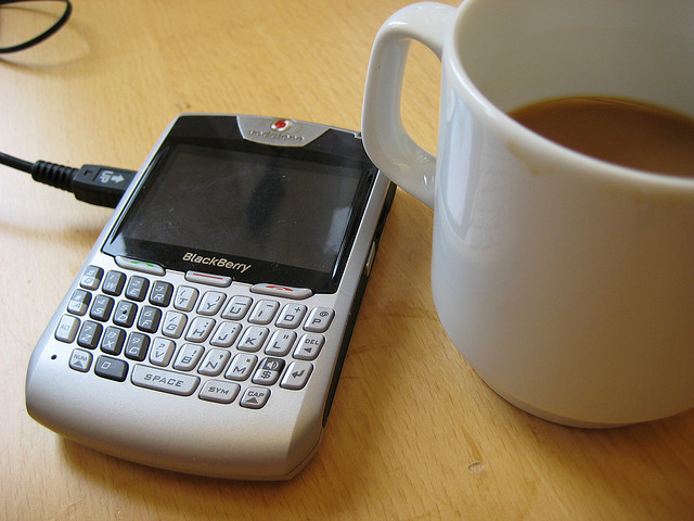 food delivery cup of coffee next to Blackberry