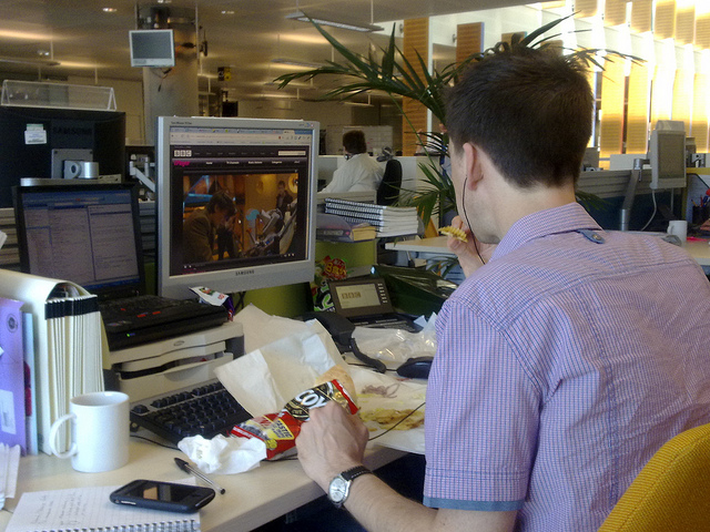 employee eating lunch in front of computer