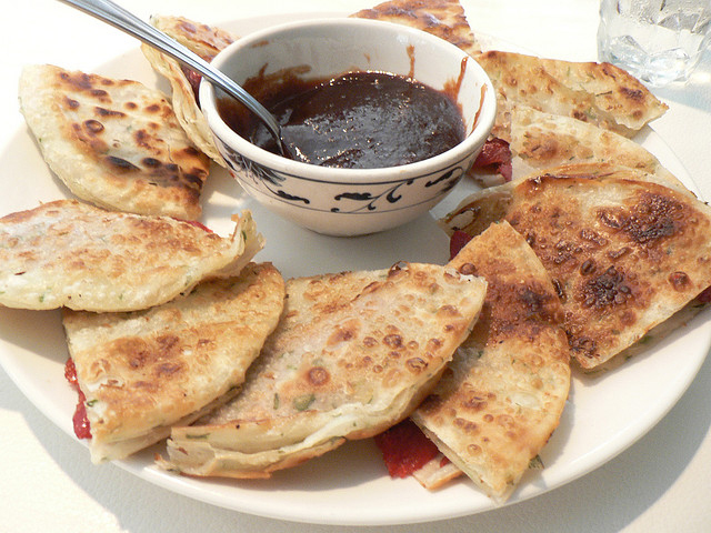 Scallion pancake with pork is served with sauce. 