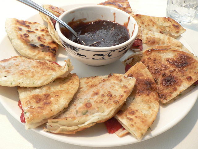 Scallion pancake with pork is served with sauce.